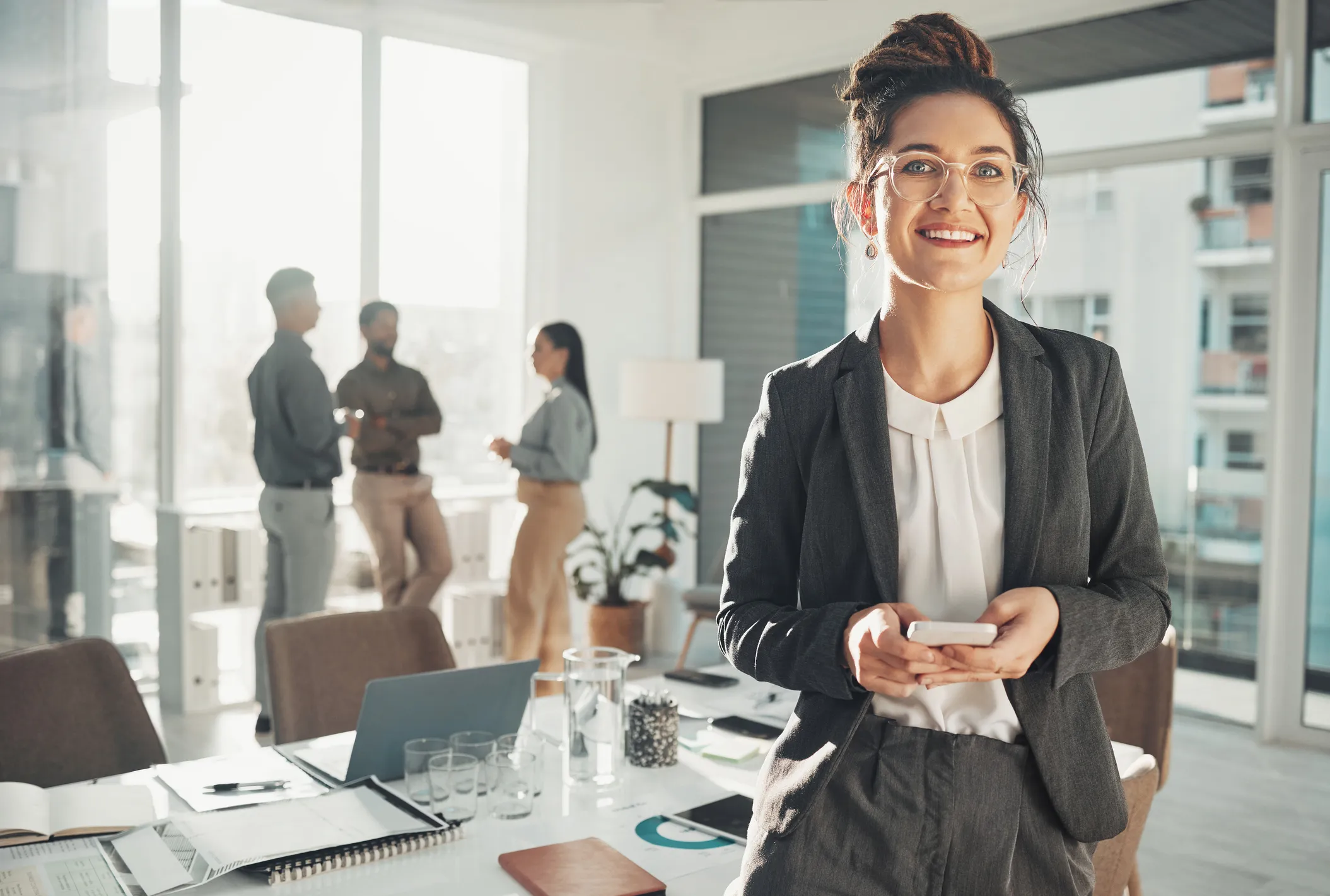 smiling female professional with a group of colleague in the background
