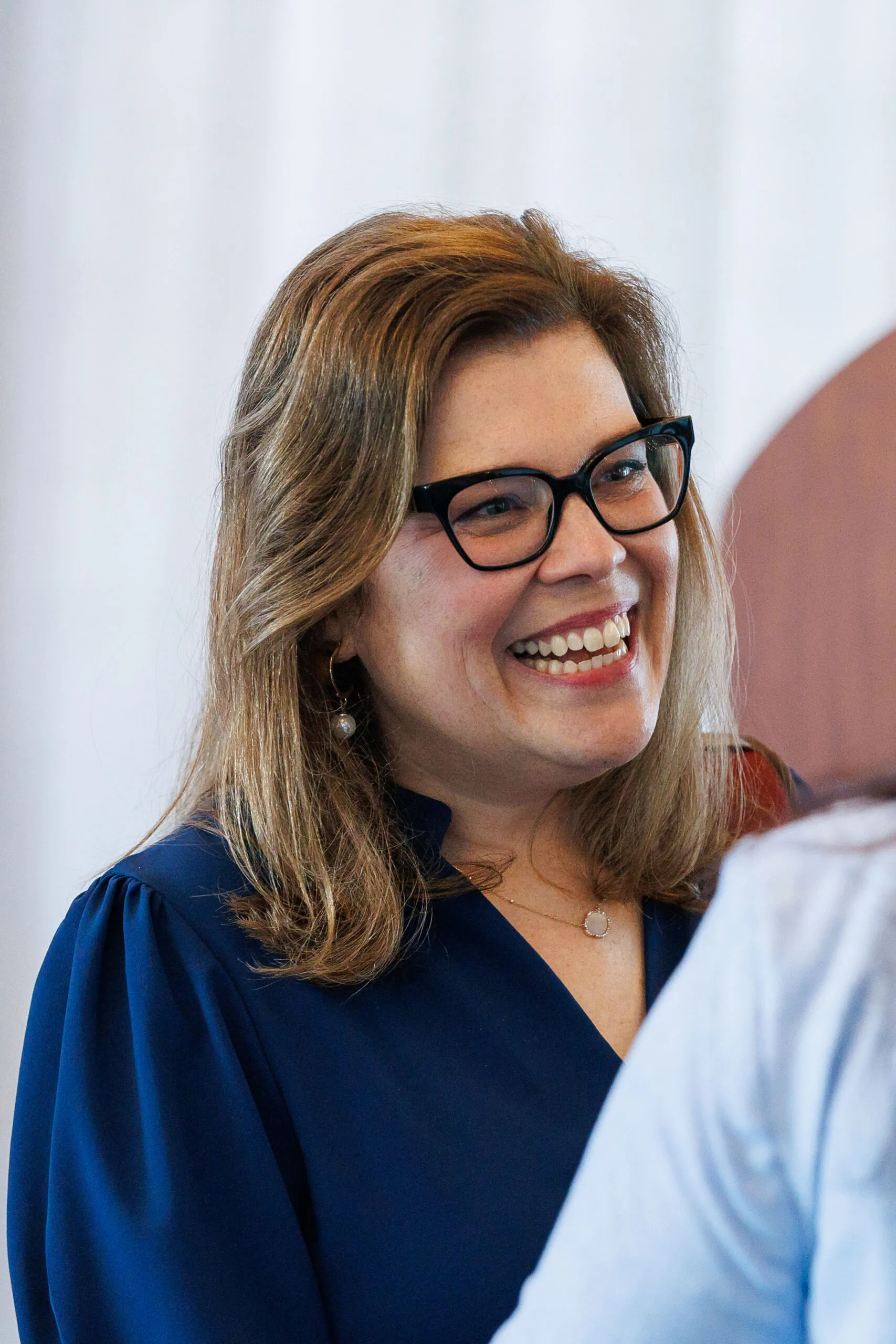 Candice Reed, EVP & Partner of Latitude, smiling while talking to someone.