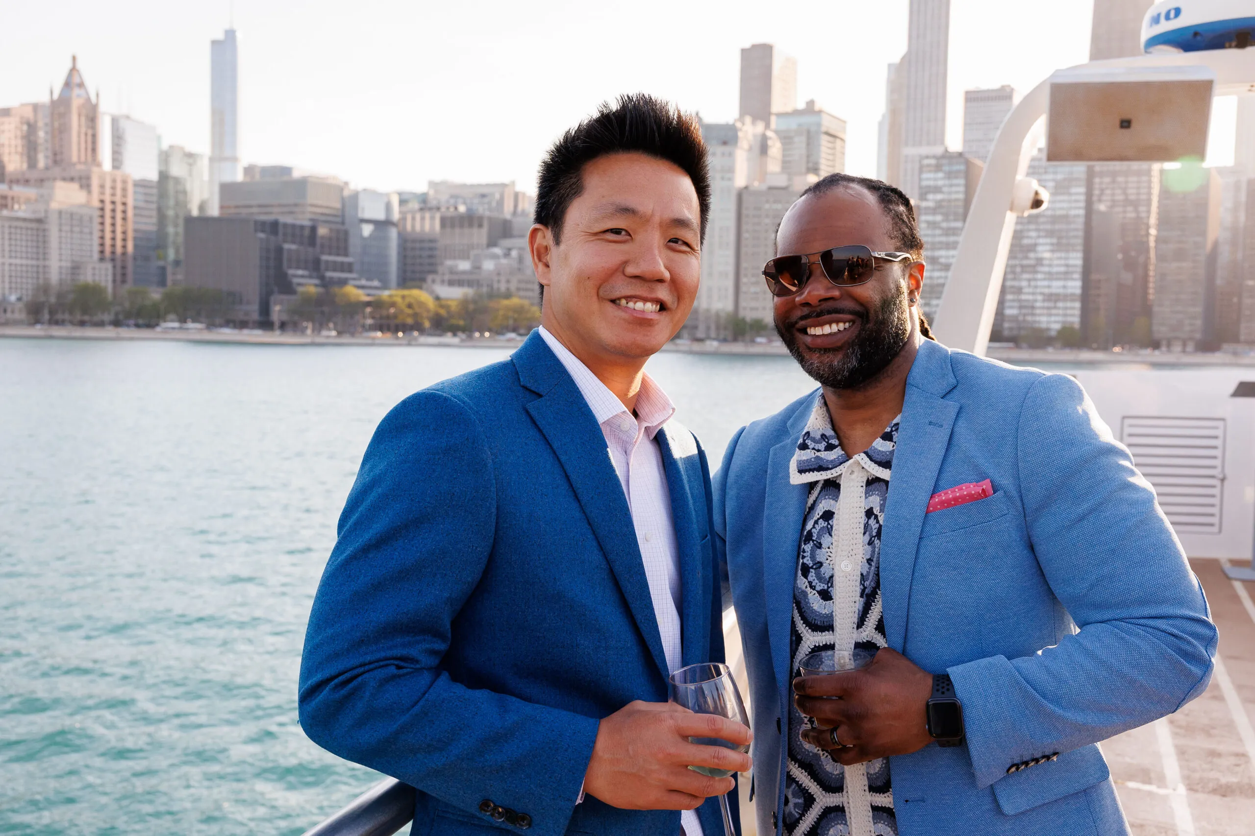 Alex Su and Justin Johnson, smiling on boat in front of Chicago skyline.