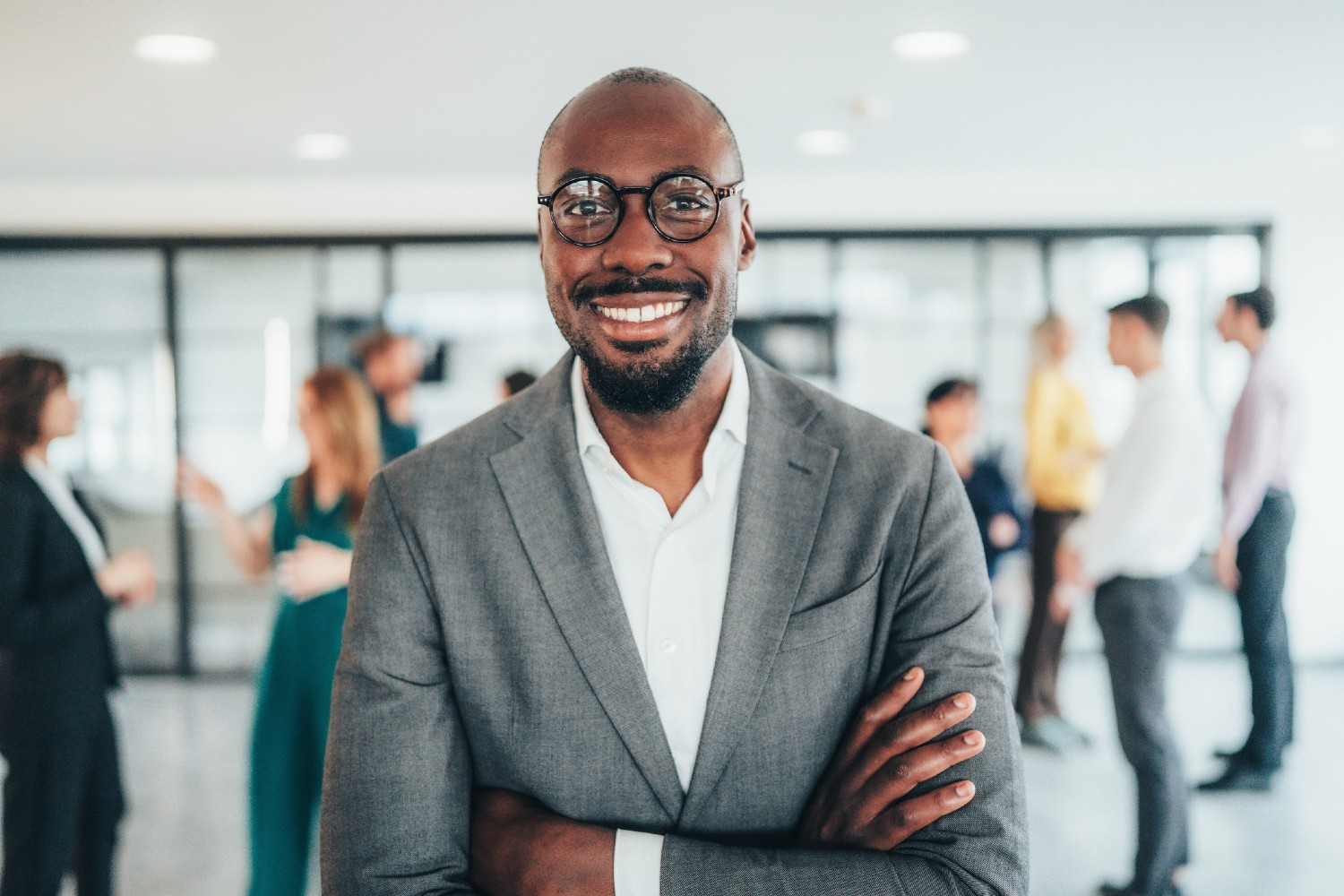 Portrait of smiling businessman with his colleagues in office lobby.