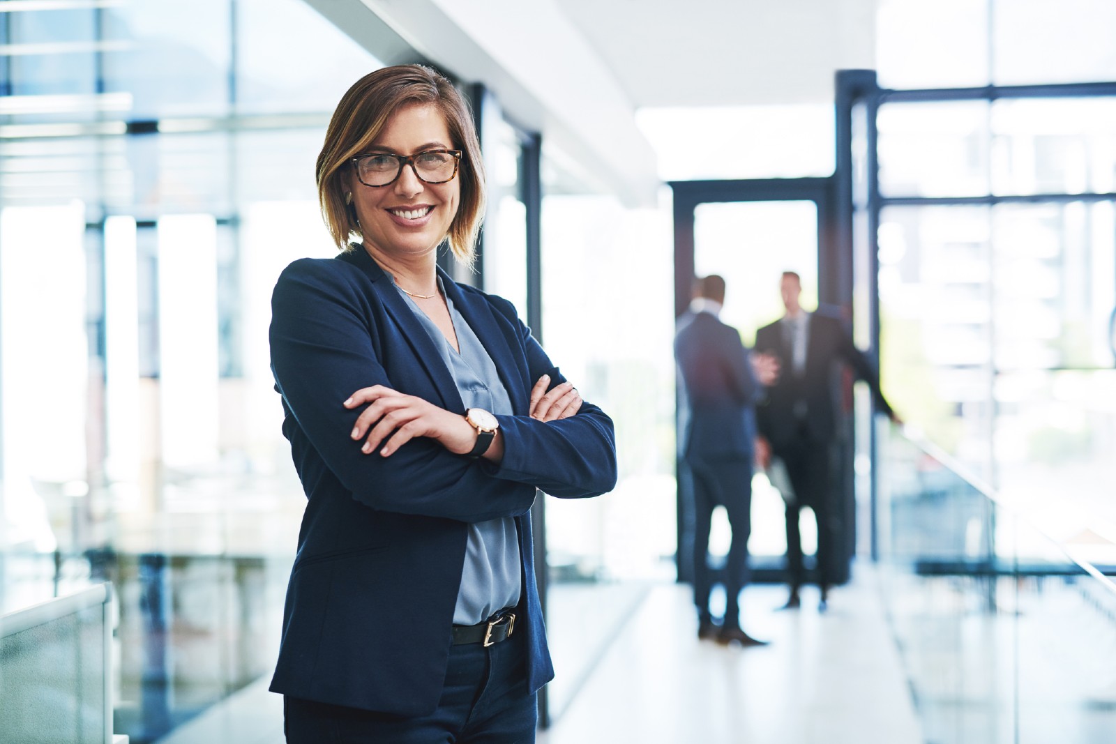 Friendly business professional smiles at camera in a modern office