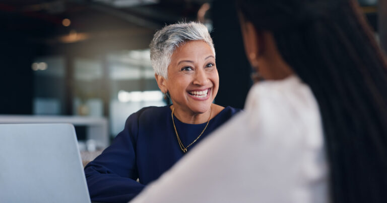 Mature woman, business and happiness with team discussion, positive feedback or investment for project.