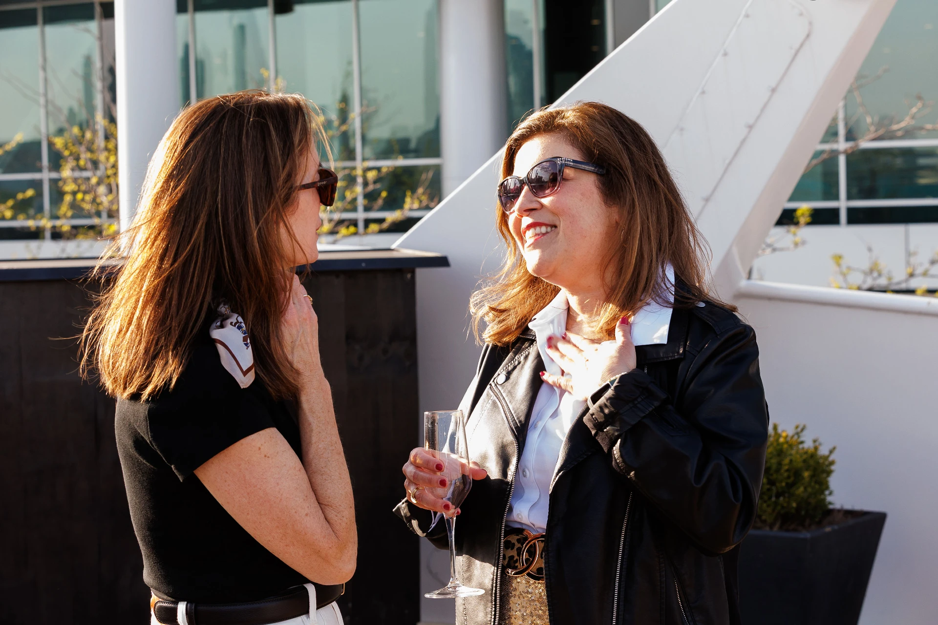 Two women talking to each other outside