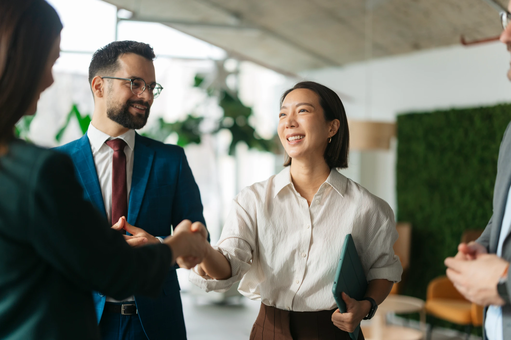 Business colleagues shaking hands, celebrating a successful agreement at the office
