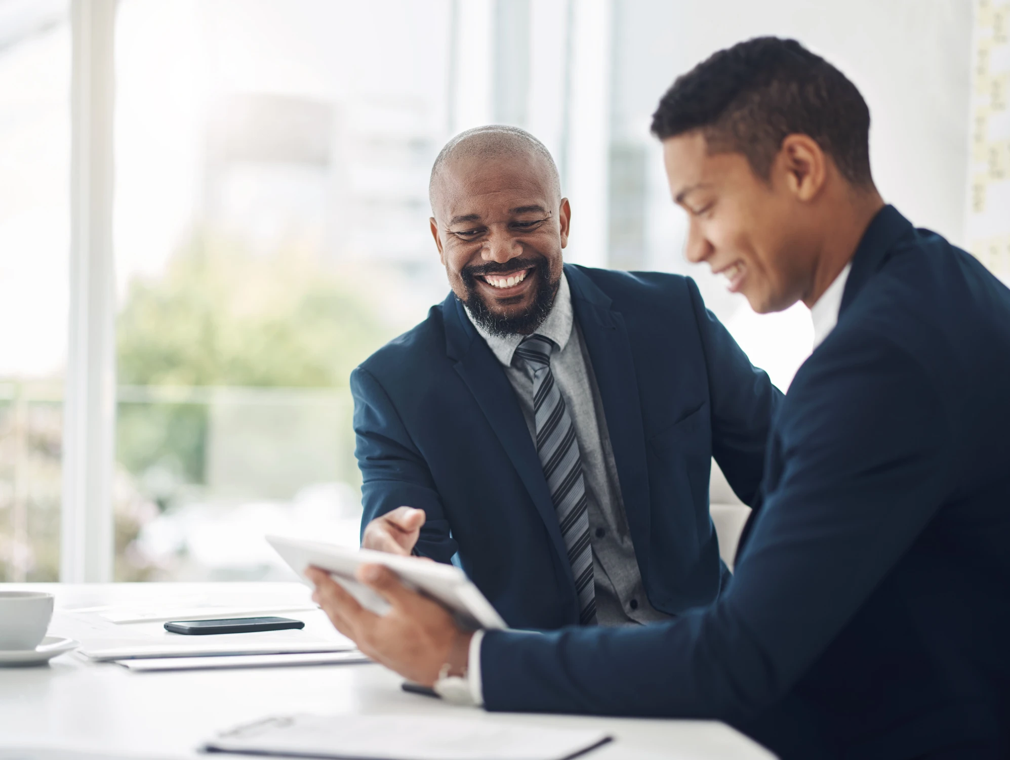 two businessmen using a digital tablet during a discussion in a modern office 